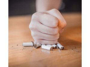 Persona rompiendo cigarrillos sobre una mesa, representación del programa para dejar de fumar con hipnosis